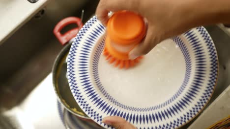 lavando platos en el fregadero de la cocina