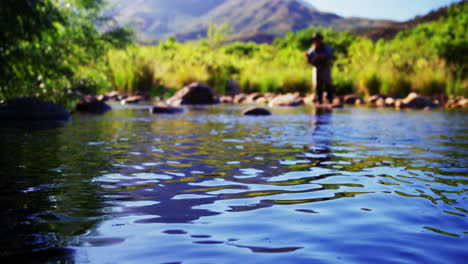 man fly fishing in river