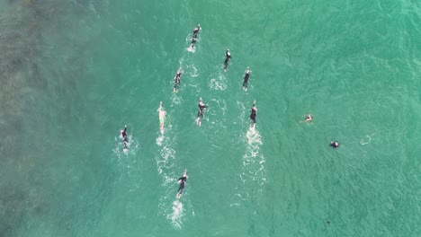 aerial footage of swimmers practicing in clear turquoise ocean waters near port campbell, australia, showcasing teamwork and athleticism