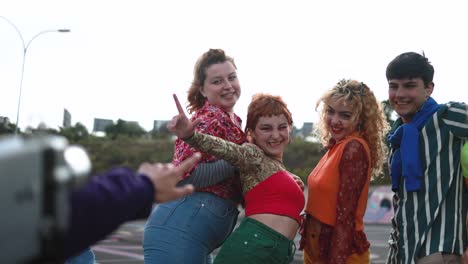 young diverse people having fun with old vintage video camera outdoor