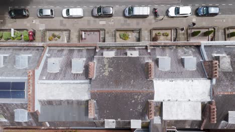 Top-down-aerial-view-of-charming-period-terraced-houses-with-traditional-chimney-stacks-lining-a-quaint-street-in-the-UK