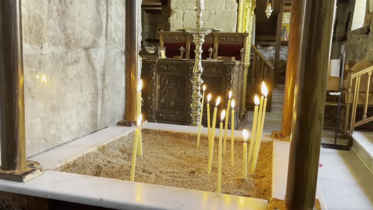 Inquadratura fissa di candele che bruciano in una vecchia chiesa