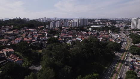 El-Dron-Se-Mueve-Hacia-Arriba-Y-Hacia-Adelante,-Revelando-El-Horizonte-De-La-Ciudad-De-São-Paulo-Al-Fondo-Y-Una-Calle-Concurrida-A-La-Derecha