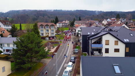 Aerial-of-Children's-Carnival-coming-through-neighborhood-streets,-Bergdietikon,-Greater-Zurich-Area,-Switzerland