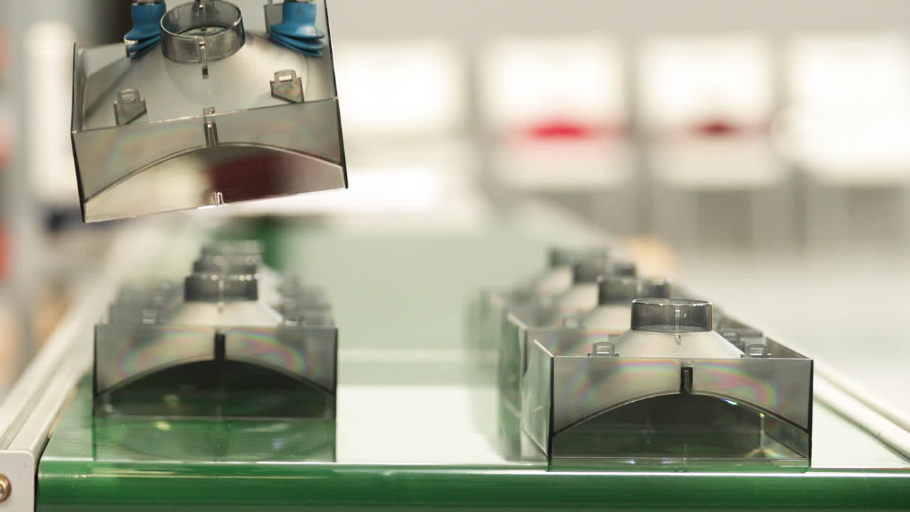 piezas de plástico terminadas liberadas por una máquina robótica dentro de una fábrica de moldeo por inyección