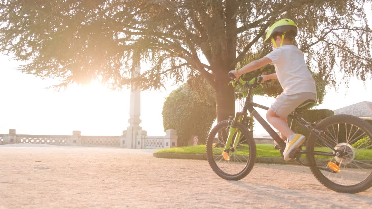Boy Riding a Bike in a Park at Sunset