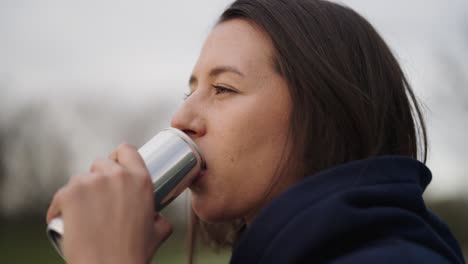 atractiva mujer caucásica morena bebida bebida de lata de aluminio