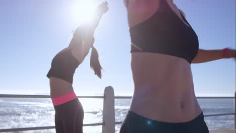 two athletic friends stretching on promenade before run