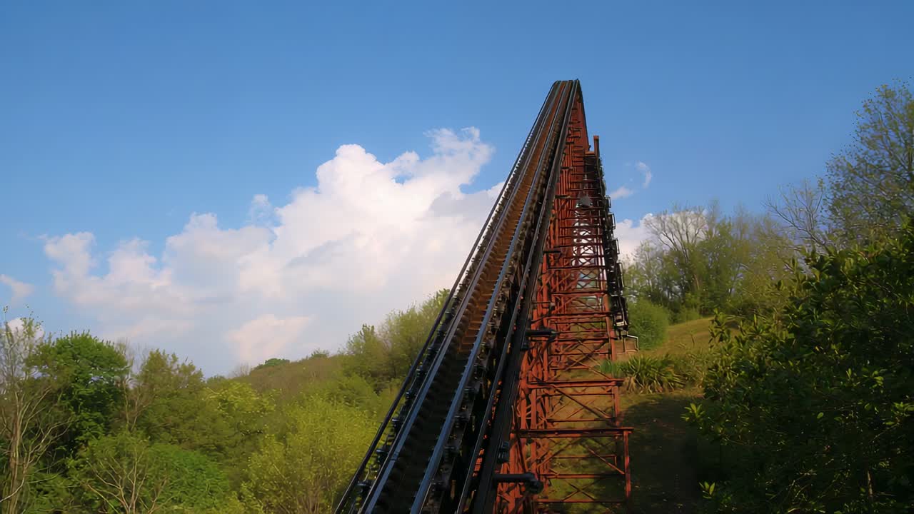 Chain lift track engaging hauling coaster train ascending lift hill at park, with safety ratchets