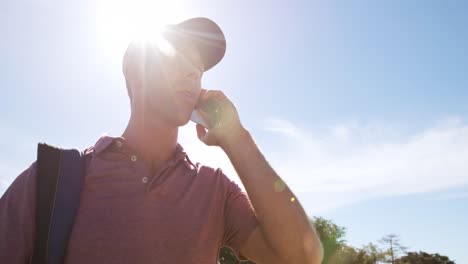 golfista caucásico usando su teléfono inteligente en un campo de golf