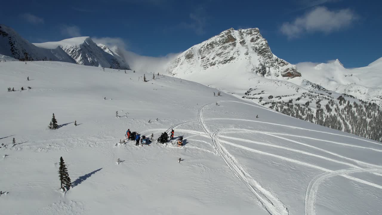 Vista aerea di motoslittisti in pausa sulla cima di una montagna con un panorama pittoresco
