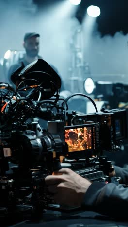 cinematographer adjusts camera equipment during a film shoot at night