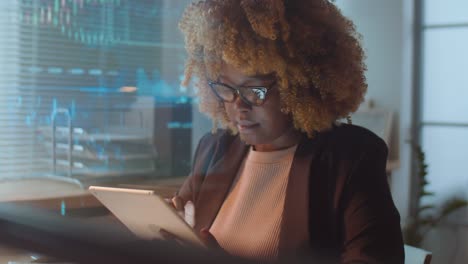 african american businesswoman working on tablet at night