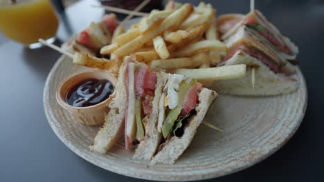 A club sandwich with french fries and ketchup