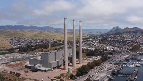 wide aerial panning shot of the defunct morro bay power plant in morro bay, california