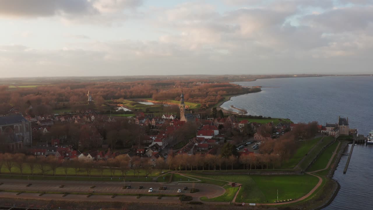 Historical city Veere with the big church and city hall tower during sunset. Drone shot