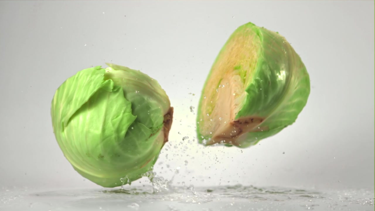 Fresh Cabbage Head Falls and Splits with Water Splash in Slow Motion
