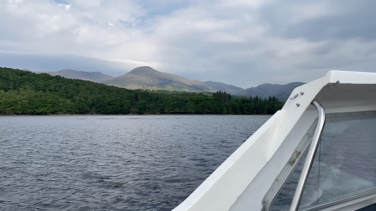 Il monte Old Man of Coniston in vista da una piccola barca bianca che naviga sul lago Coniston nel Lake District, Regno Unito