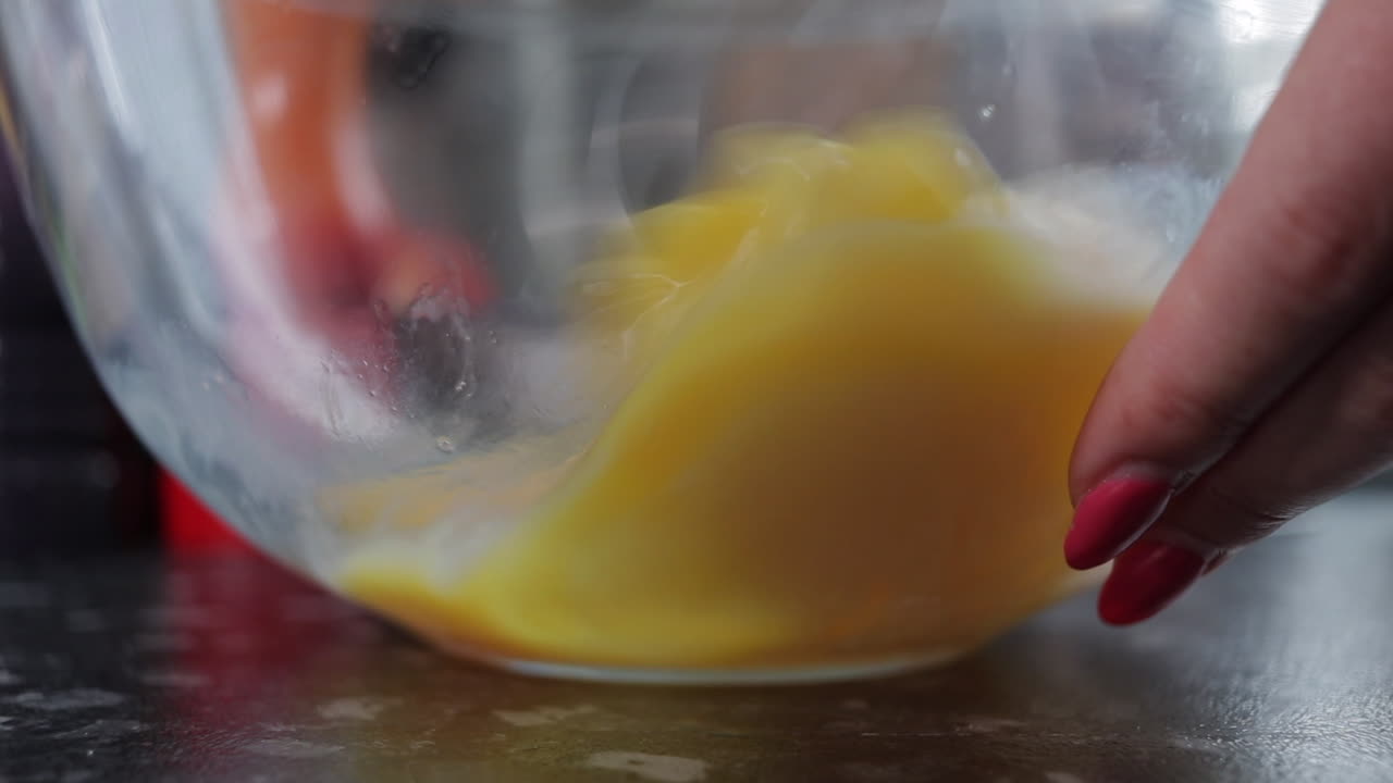 mujer batiendo huevos en un recipiente de vidrio, cerrar