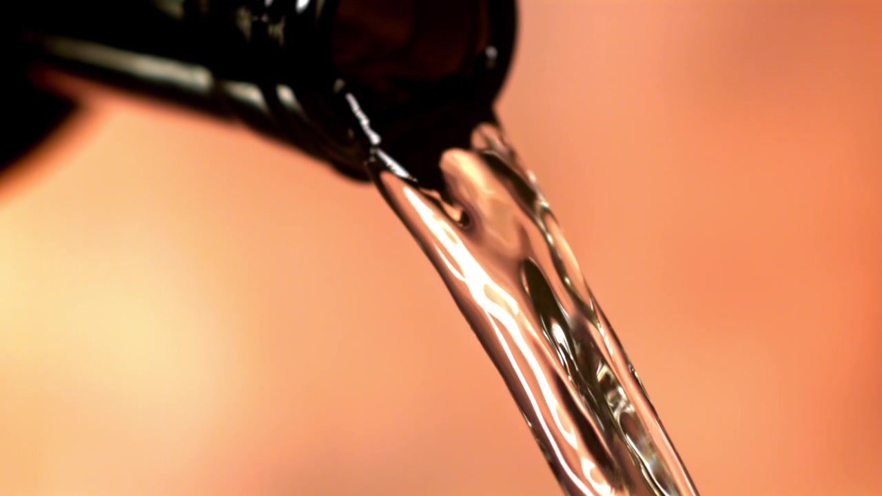 Clear Liquid Pouring from Bottle in Slow Motion