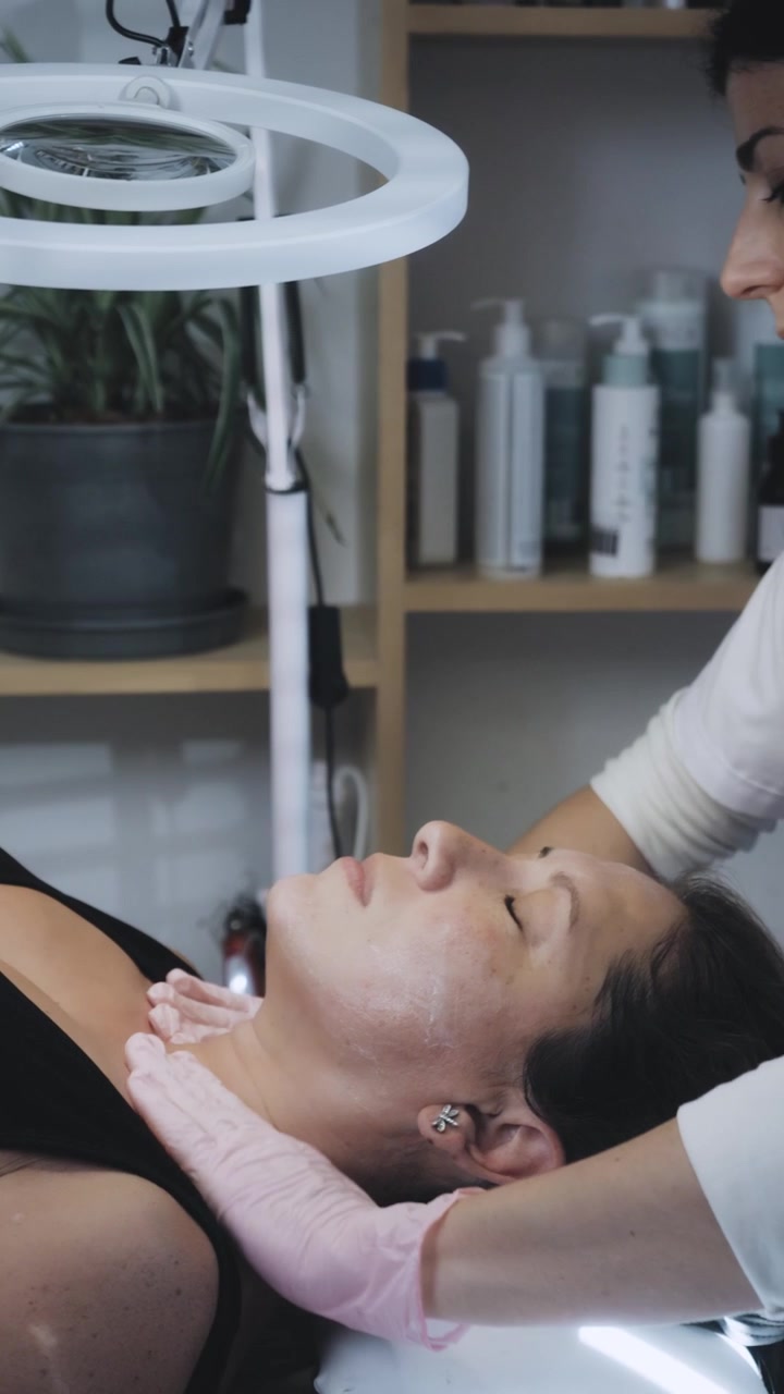 Estetista che esegue un massaggio facciale su una cliente in una spa