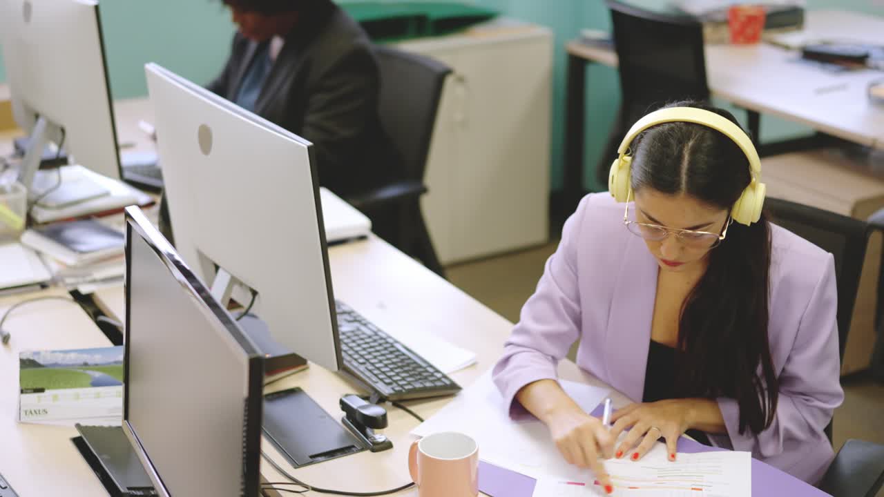 Concentrated woman working in paperwork in a modern coworking