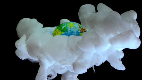 planet earth and white watercolor ink in water on a black background
