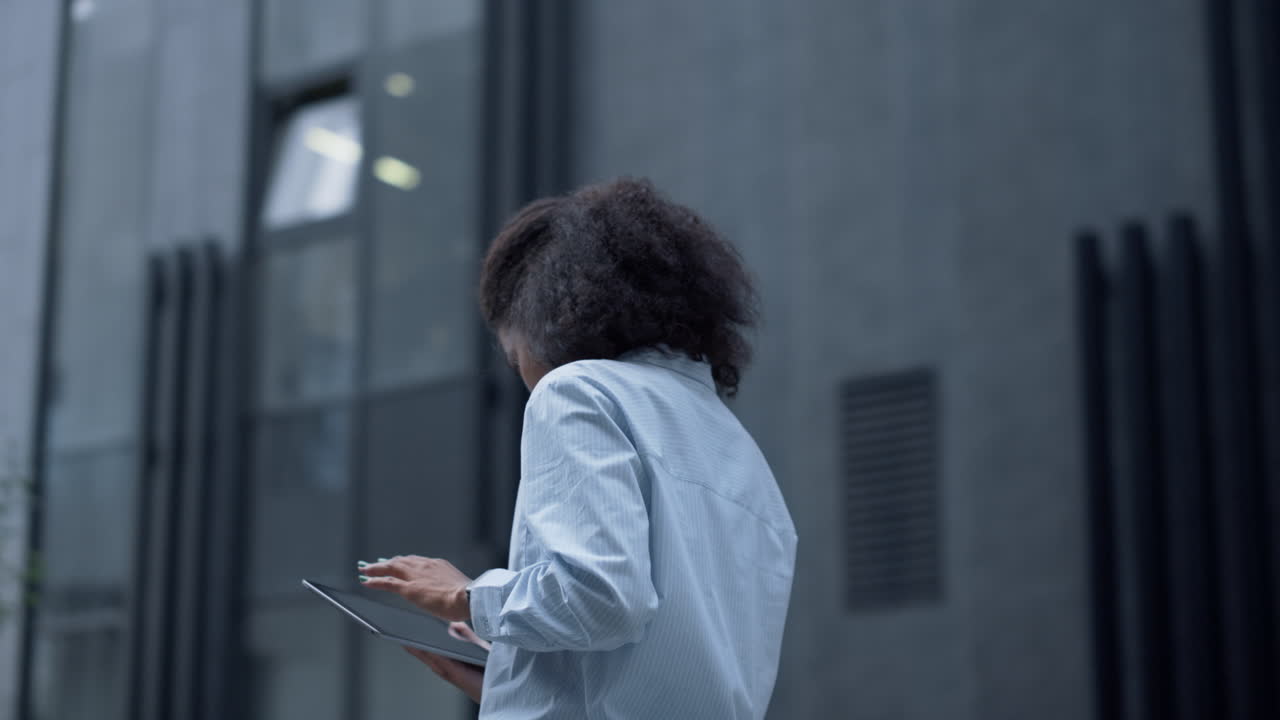 Analista professionale che lavora con un tablet in piedi in un moderno edificio per uffici.