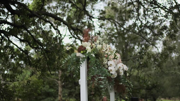 Blomstrende blomster dekoreret på en buegang med naturbaggrund til bryllup i dagtimerne