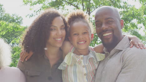 Portrait-Of-Smiling-Multi-Generation-Family-At-Home-In-Garden-Together