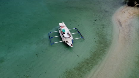 Bahnaufnahme-Eines-Einsamen-Bootes,-Das-Entlang-Einer-Weißen-Sandbank-Verankert-Ist