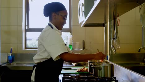 Female-chef-preparing-food-in-kitchen-at-restaurant-4k