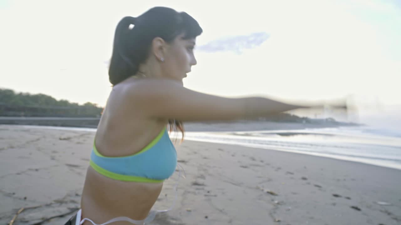 mujer calentándose en la playa al atardecer