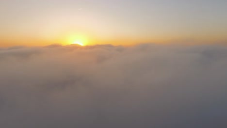 4k drone footage from above the clouds while sunrise