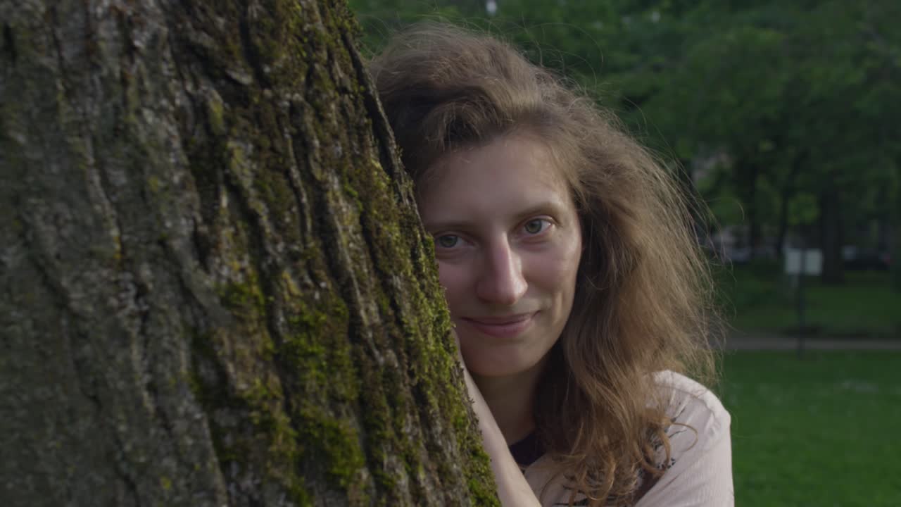 아름다운 여자가 나무 뒤에서 어나오고 놀이하고, 반복해서