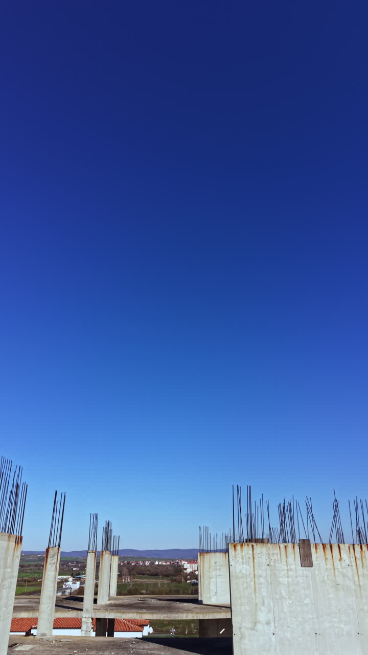 Struttura in cemento che emerge sotto un cielo blu, che mette in mostra l'architettura moderna e il progresso della costruzione in un vivace contesto urbano