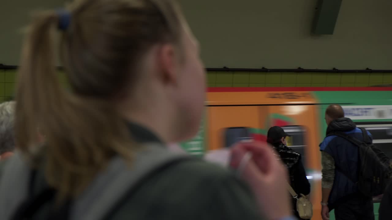 Giovane donna si prende il tempo di indossare la mascherina prima di salire sul treno della metropolitana.