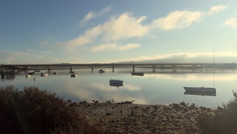 peaceful river scene with boats and bridge