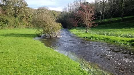 desbordamiento estallido sinuosa orilla del río inundación pacífica saturada iluminada por el sol norte de gales prado