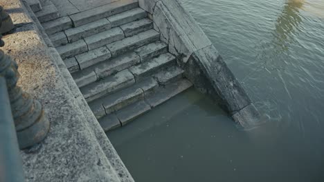 stone staircase partially submerged in water during the budapest flood 2024, leading into the danube