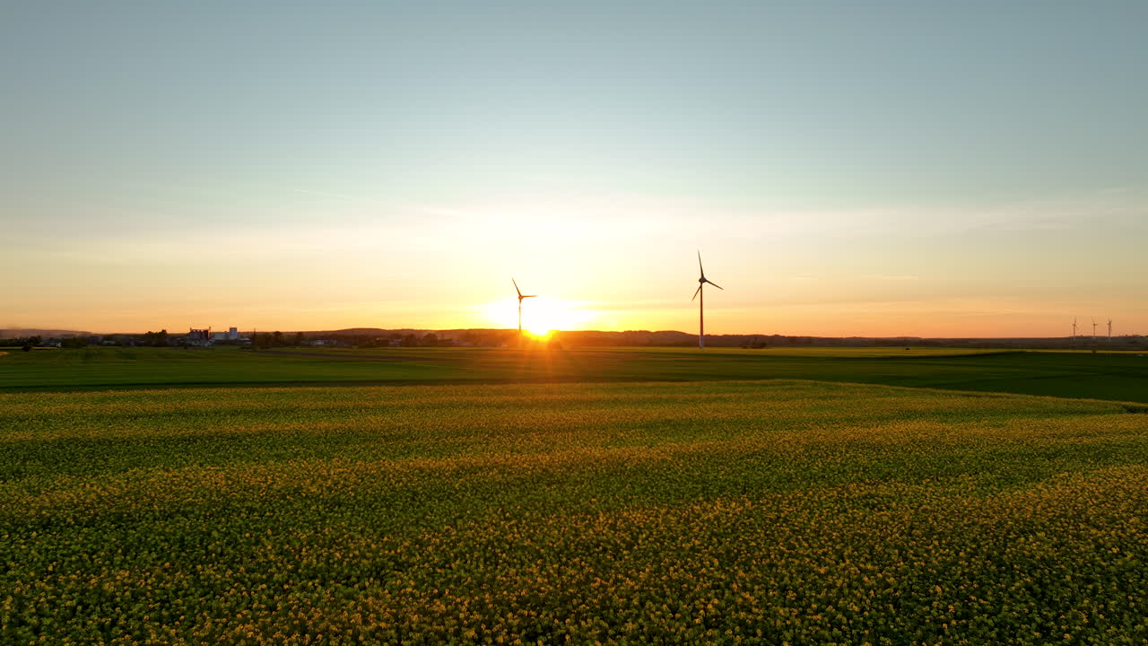 해가 지는 동안 풍력 터빈 이 있는 초록색  의 공중 사진