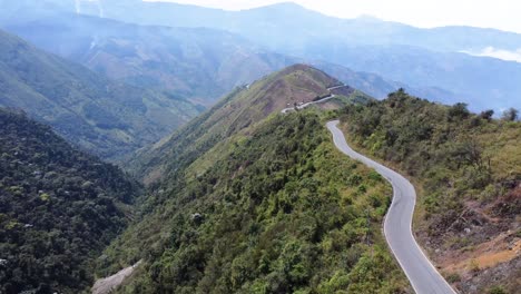 drone flies along beautiful curvy road on lush green mountain, surrounded by valleys and mountain range between guaranda and montalvo, bolivar province, ecuador