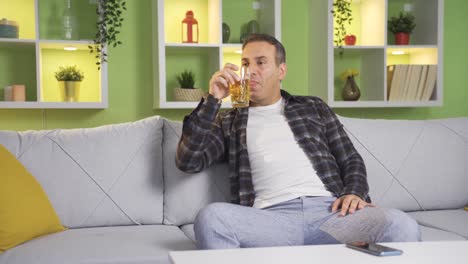 drunk man drinking alcohol thoughtful and emotional at home