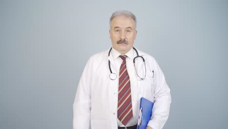 el médico mira a la cámara con una expresión sencilla.