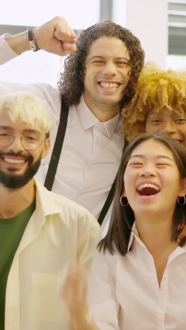 Team of coworkers celebrating raising fist and looking at camera