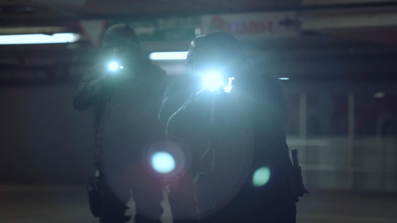 무장 한 스와트 장교 들 이 손전등 을 들고 저격 소총 으로 총 을  ⁇ 고 있다