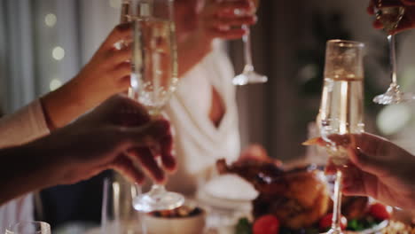 hands with glasses of champagne clink glasses over the festive table. celebration of new year and christmas