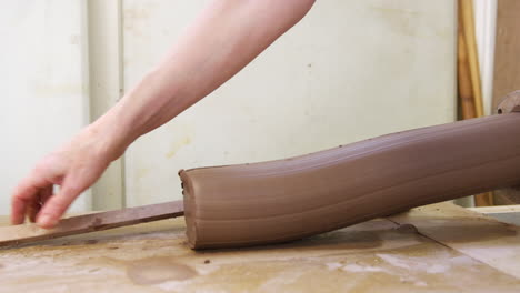 Close-Up-Of-Male-Potter-Measuring-And-Cutting-Clay-Before-Working-It-With-Hands-In-Ceramics-Studio