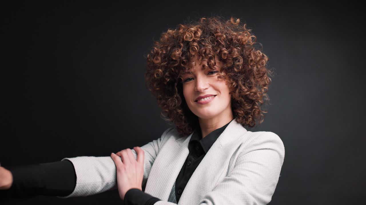 Cheerful female executive in formal suit in studio