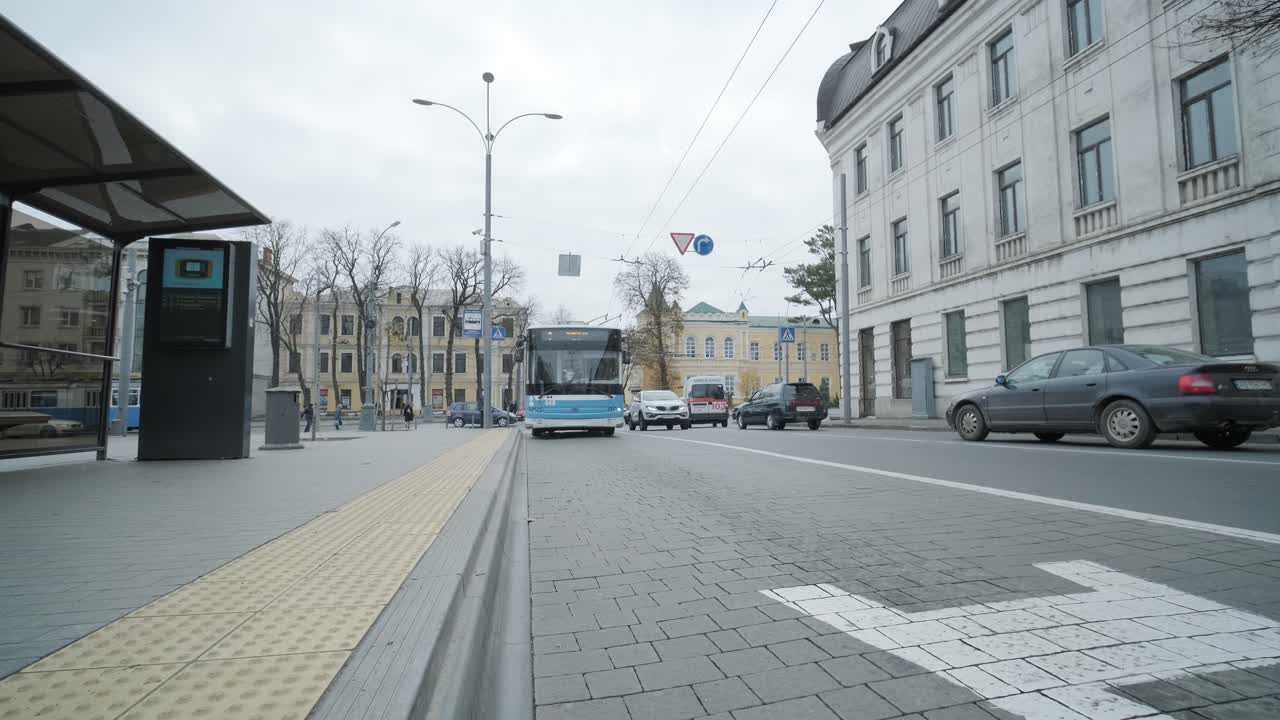 женщина в инвалидном кресле ждет автобуса на остановке